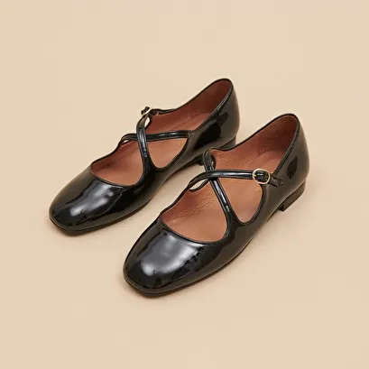 Ballet flats with crossed straps in black patent and ecru leather