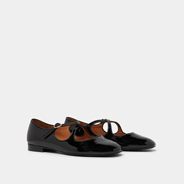 Ballet flats with crossed straps in black patent and ecru leather