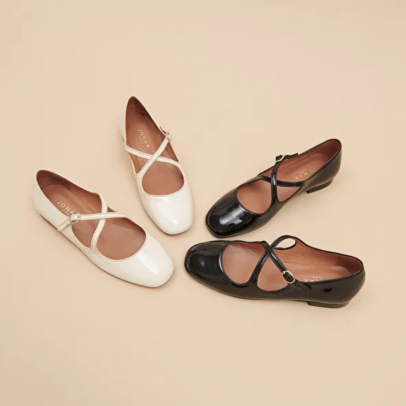 Ballet flats with crossed straps in black patent and ecru leather